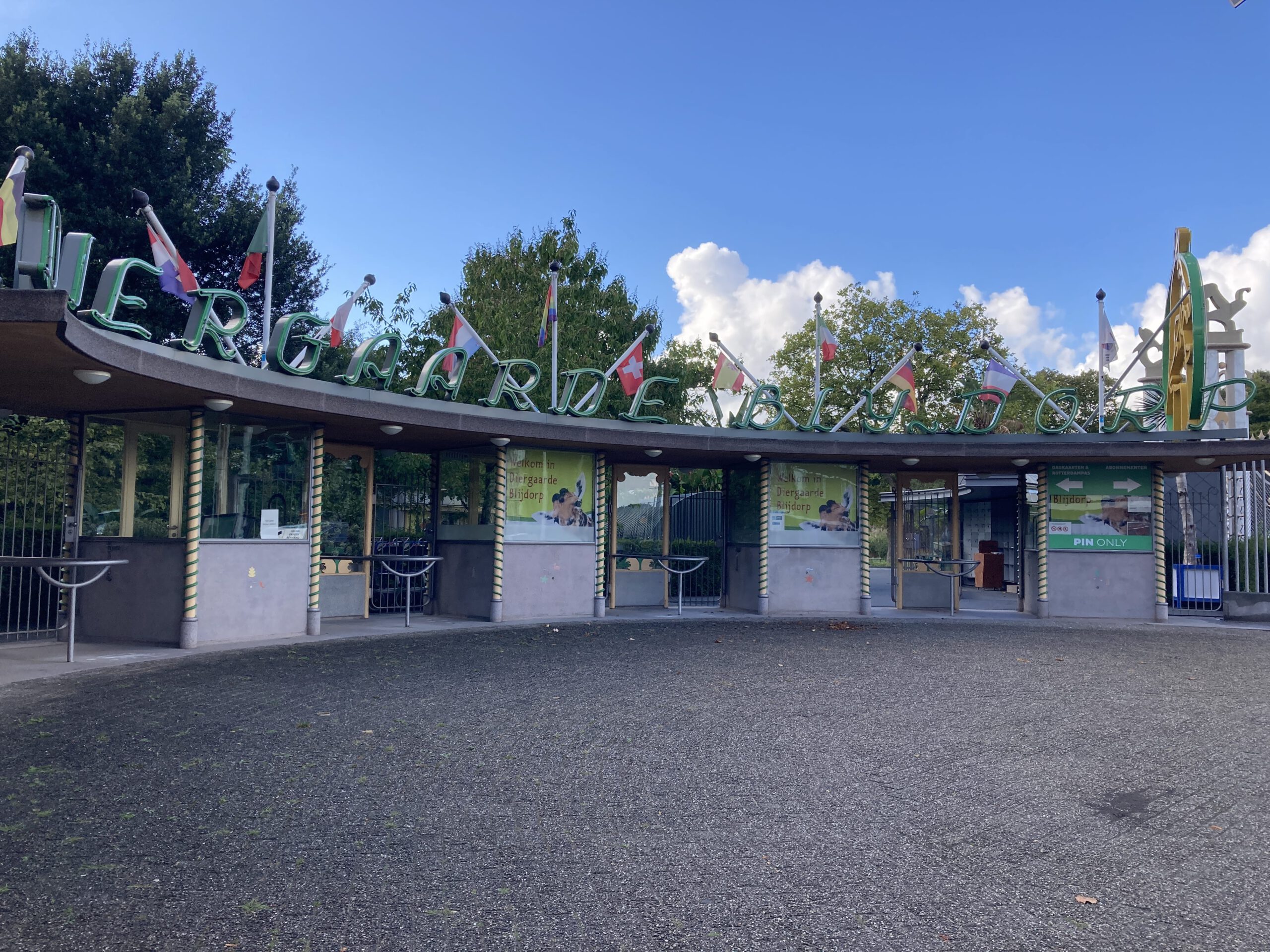 Oude ingangspoort van Diergaarde Blijdorp, de dierentuin in Rotterdam met blauwe lucht en een paar wolken