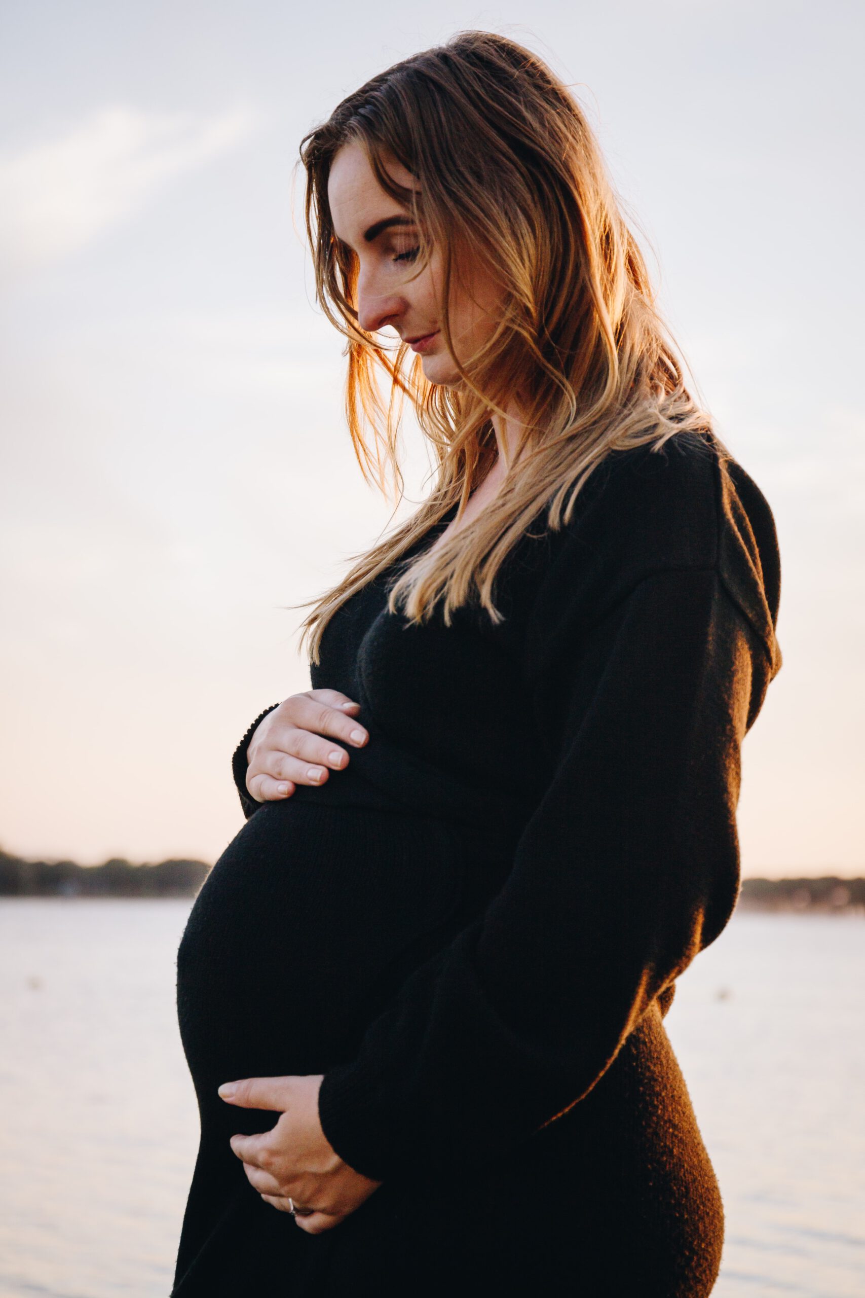 Zwangerschap foto van moeder met handen om haar bolle buik gevouwen