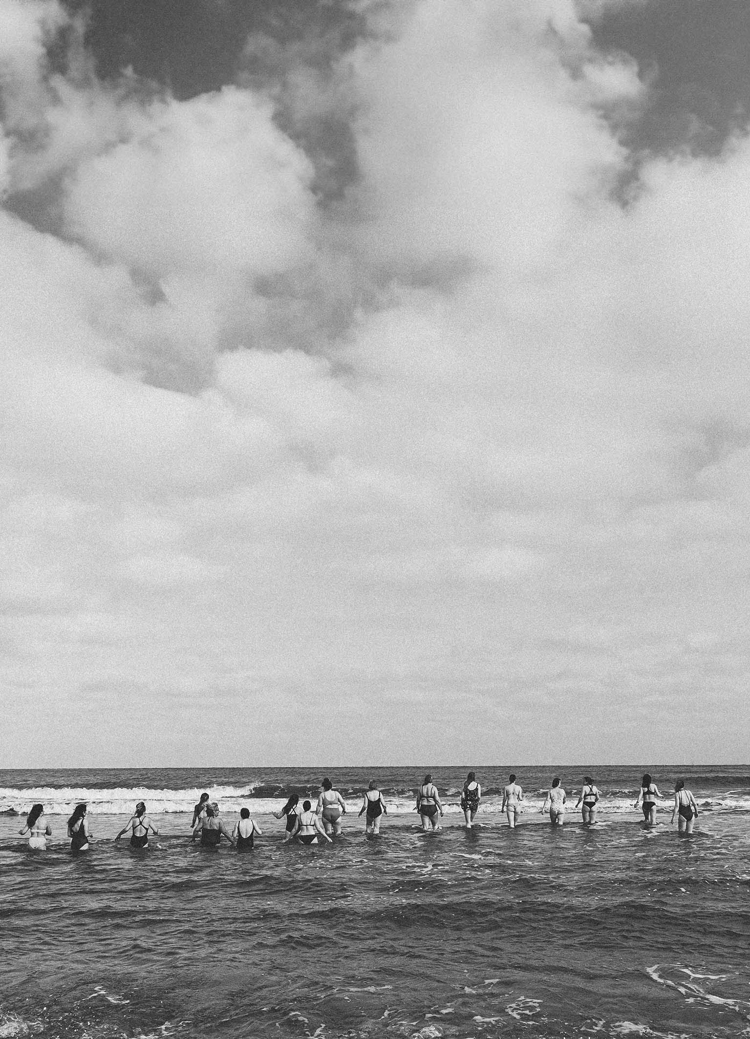 Zwart wit foto van een groep vrouwen die een duik in de voorjaarszee nemen in de buurt van Den Haag