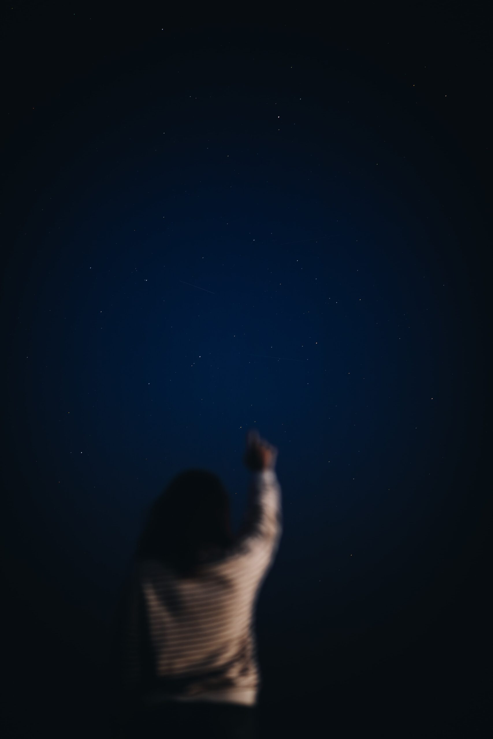 Foto van een meisje dat wijst naar de sterren
